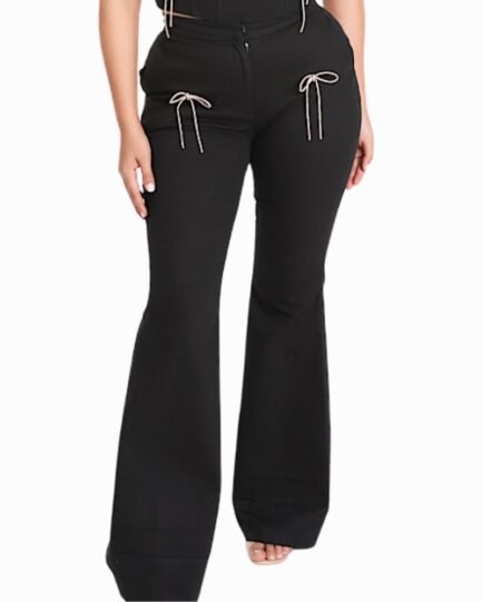 Woman wearing black Rhinestone Bow Flare Pants with sparkling rhinestone bows and a dramatic flared hem